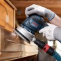 Bosch Exzenterschleifer beim Schleifen von Holzmöbeln mit Netzschleifscheibe. Staubabsaugung angeschlossen.