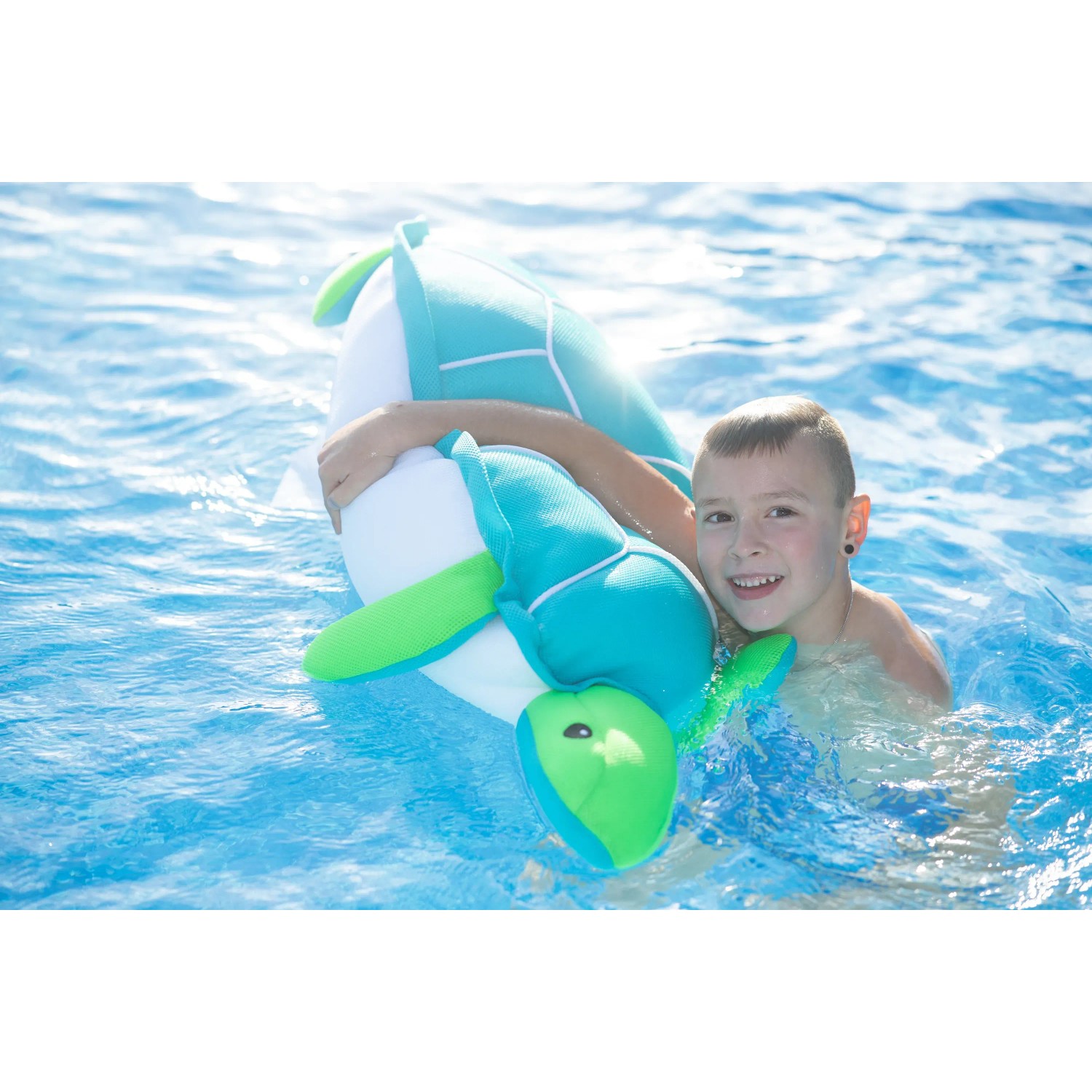 Junge schwimmt mit blau-grüner Westmann Pool Buddy Schildkröte im Pool.
