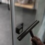 Schwarze Schiebetür mit Glasabzieher für einfache Reinigung im Bad.