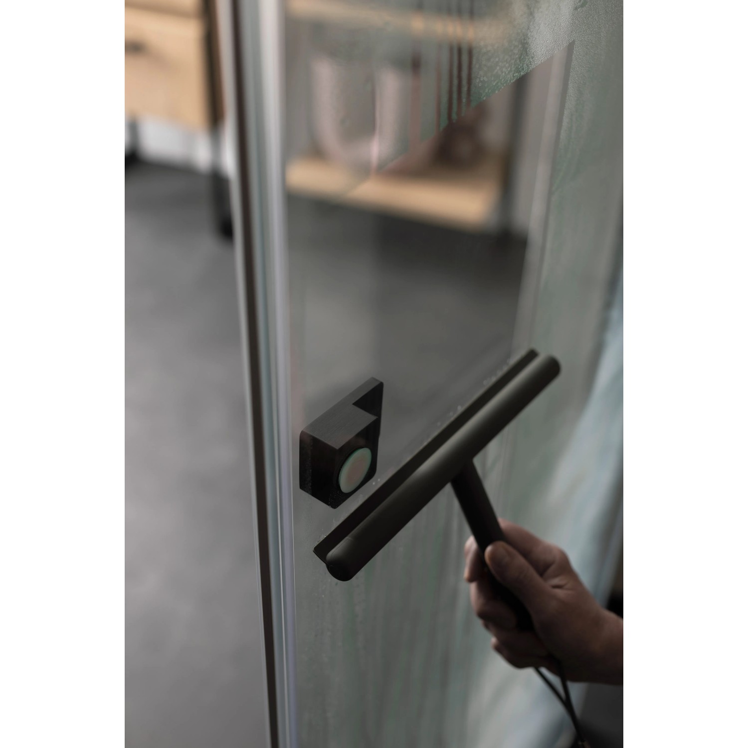 Schwarze Schiebetür mit Glasabzieher für einfache Reinigung im Bad.