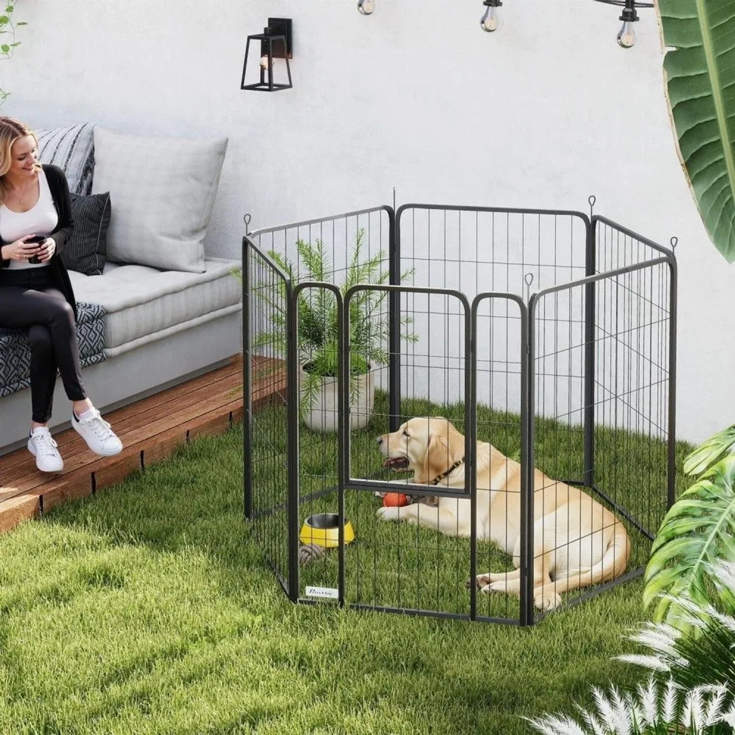 Schwarzer PawHut Stahl Welpenlaufstall im Garten mit liegendem Labrador, Napf und Spielzeug. Flexibles Hundegehege.