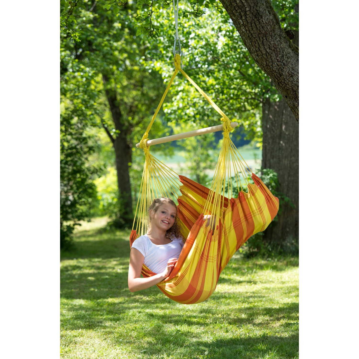 Amazonas Hängesitz Relax Orange, 130x100 cm, mit Person im Garten unter Baum.