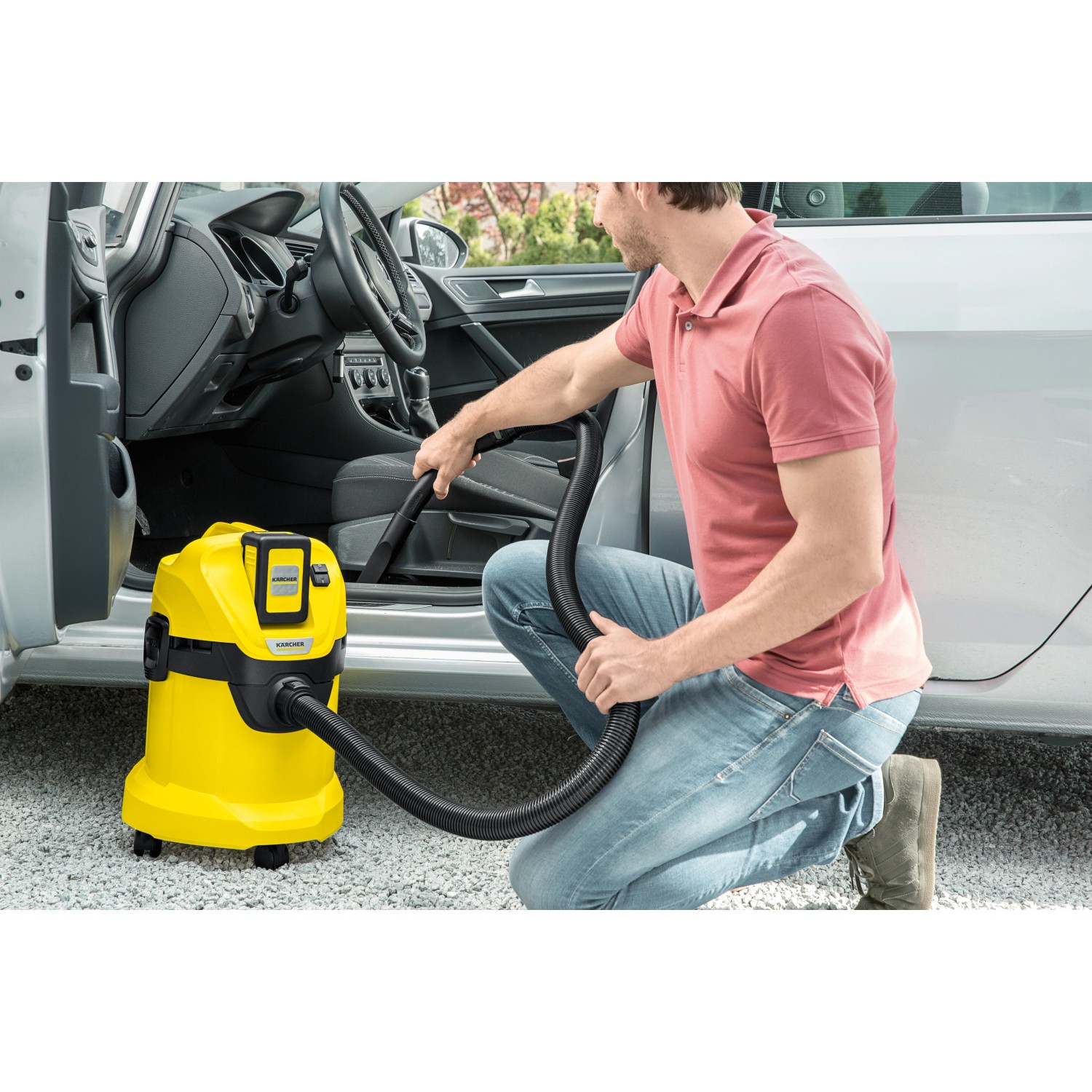 Gelber Kärcher Akku-Mehrzwecksauger WD 3 Battery beim Reinigen eines Autoinnenraums.