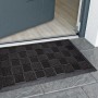 Graue OBI Gummimatte (40x60 cm) mit Noppen vor einer Tür. Fußmatte für den Außenbereich.