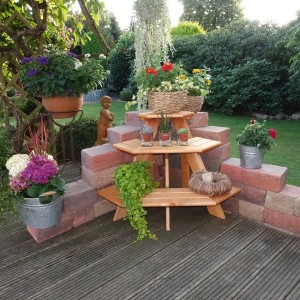 Honigbraune, 3-stufige Blumentreppe Eckelement aus Kiefernholz im Garten.