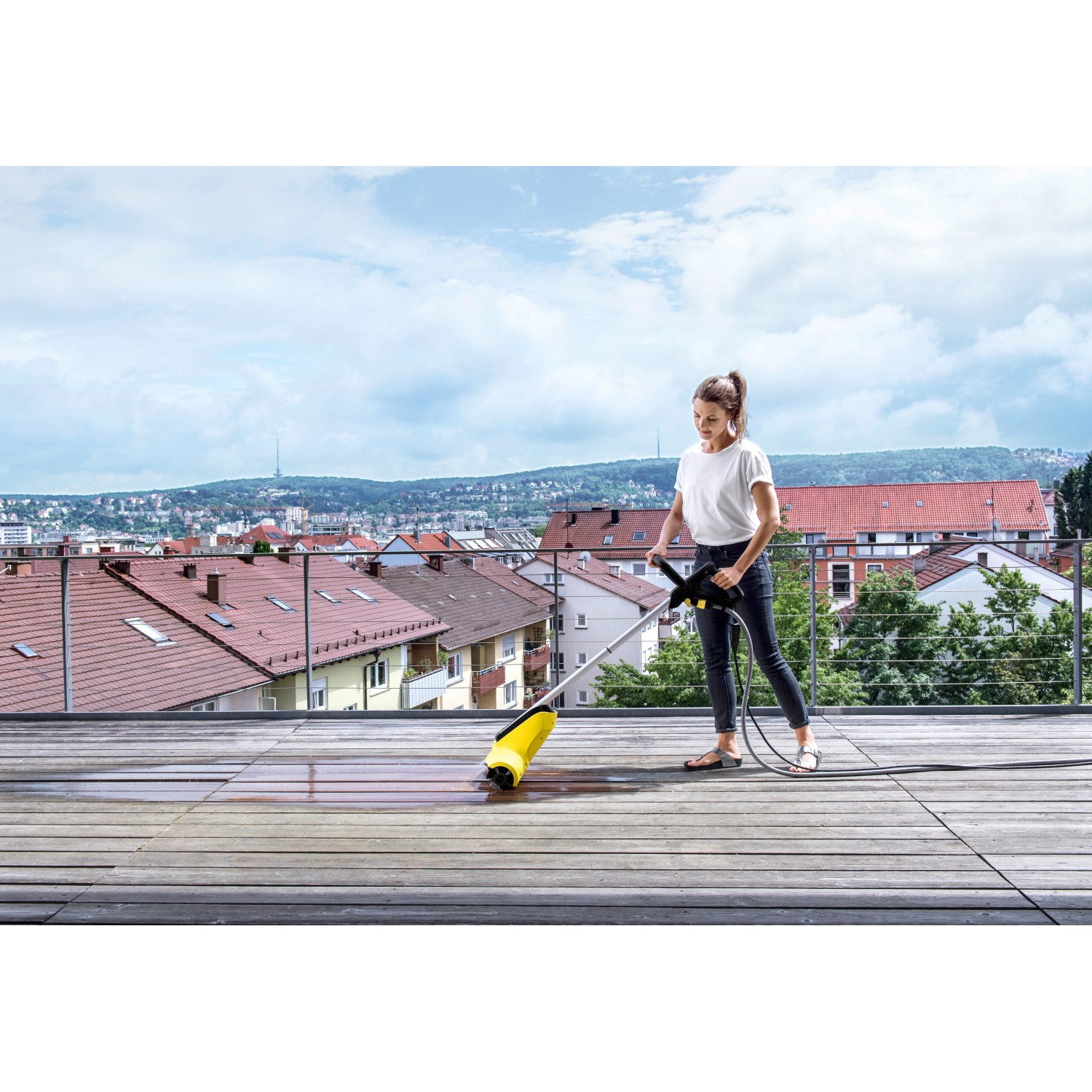Frau reinigt Terrasse mit Kärcher Terrassenreiniger PCL 4 Flächenreiniger.