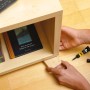 Anwendung von Uhu Alleskleber Super Transparent 7g zum Kleben eines Holzstücks an ein Regal.