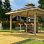 Weka Freizeitlaube Rimini Spar-Set (304x304 cm) mit Tresen und Barhockern auf Holzterrasse.