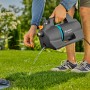 Gardena Gartenpumpe 4300 Silent in Aktion: Graue Pumpe mit blauem Akzent beim Wasserablassen im Garten.