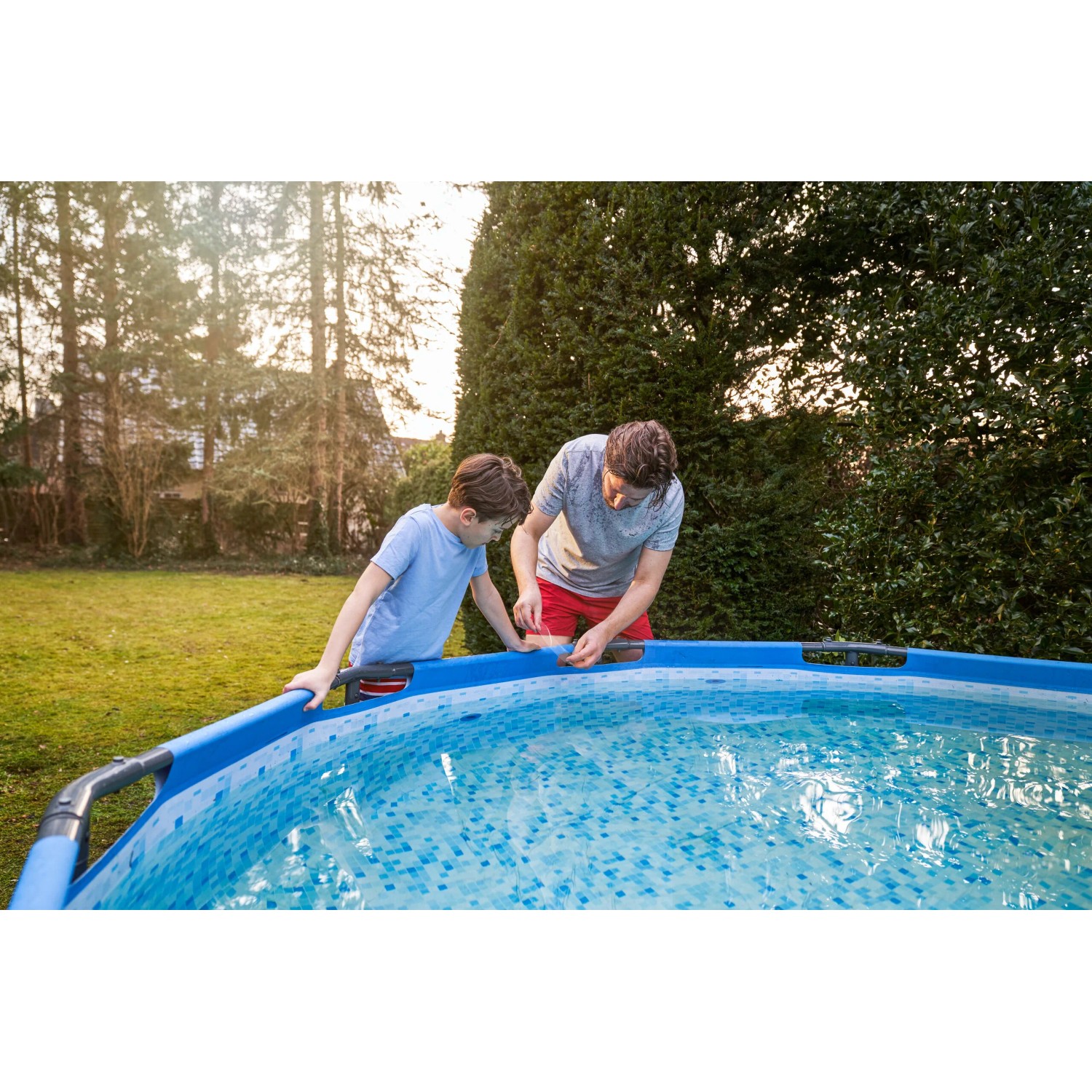 Vater und Sohn reparieren Pool mit transparentem Tesa Reparaturband Ultra Power Under Water.