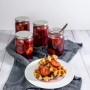 Vier Dr. Oetker Einmachgläser 630ml mit Pflaumenfüllung und Waffeln auf einem Tisch.