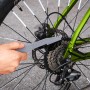 Fahrrad-Pflegeset: Hand reinigt mit Bürste den Zahnkranz eines Fahrrads.
