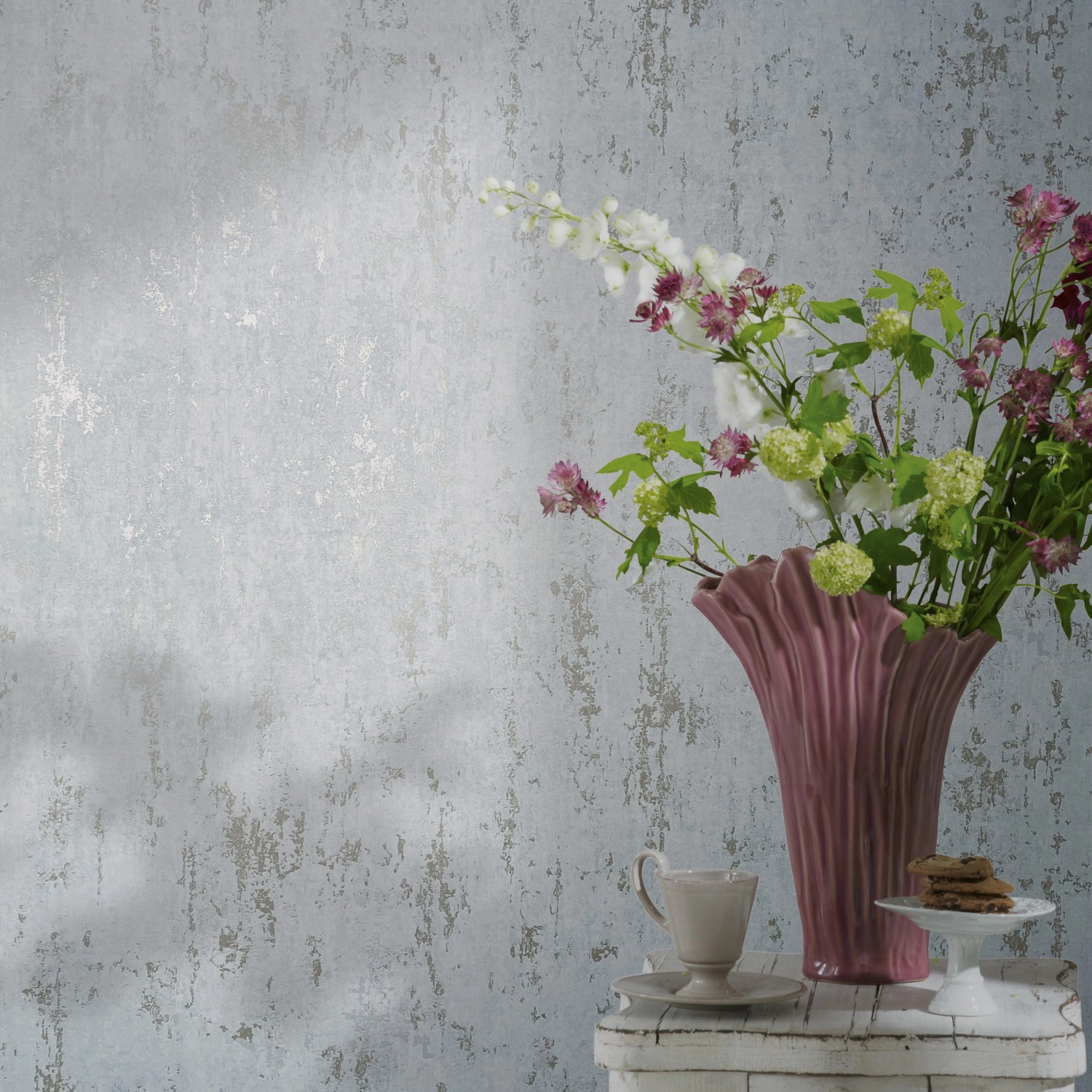 Marburg Vliestapete Betonoptik in Weiß-Gold mit Blumen in pinker Vase und Geschirr.