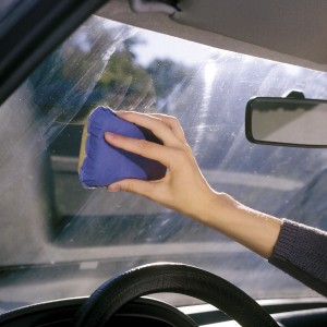 Anwendung des LUX Antibeschlagschwamms auf einer Autoscheibe.