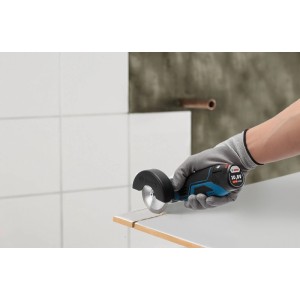 Hand schneidet Fliese mit blau-schwarzem Bosch Professional Akku-Winkelschleifer GWS 12 V-76. Kompakte Schleifmaschine.