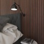 Akustikpaneel Lux Walnuss an Schlafzimmerwand mit Lampe und Bett im Schlafzimmer.
