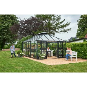 Juliana Gewächshaus Grand Oase 18, anthrazit-schwarz, mit Familie im Garten. Begehbares Glas-Gewächshaus mit Fundamentrahmen.