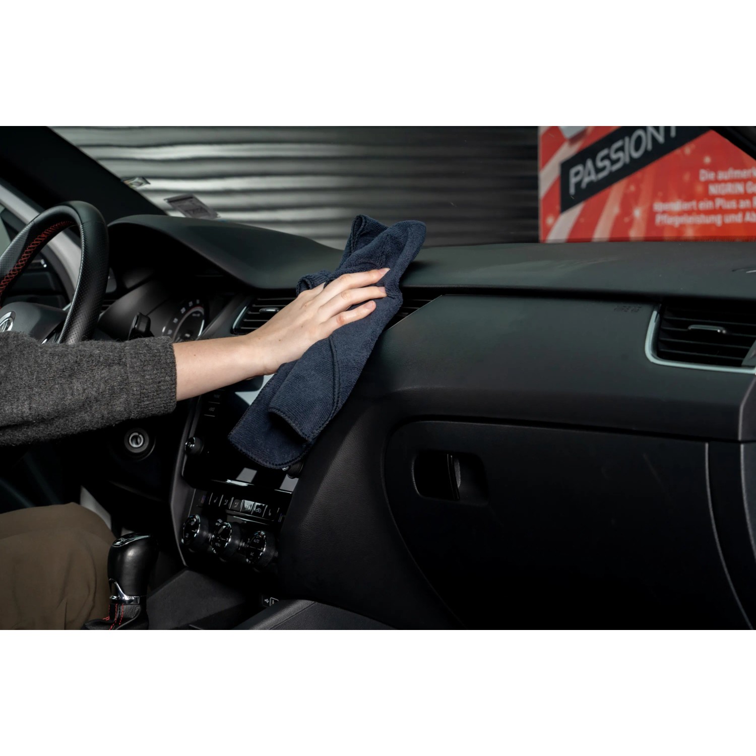 Nigrin Cockpit-Spray Vanille Anwendung: Cockpit-Reinigung mit Tuch im Auto.