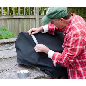 Mann repariert Abdeckung mit Duck Tape® Gewebe-Klebeband in Silber. Rolle Klebeband sichtbar.