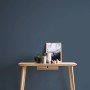 Michalsky Living Change Vliestapete Uni Blau an Wand hinter Tisch mit Deko.