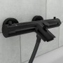 Schwarze, matte Schütte Thermostat Badewannenarmatur London mit Brauseschlauch an grauer Wand.