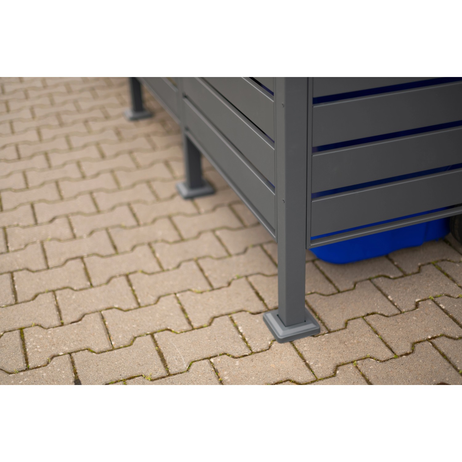 Westmann Mülltonnenverkleidung Planum, Metall, Anthrazit/Grau, Detailansicht der Füße und einer blauen Mülltonne.