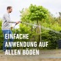 Anwendung von Compo Rasen Nachsaat Turbo: Mann bewässert Rasenfläche mit Gartenschlauch.