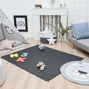 Schwarze LittleTom Puzzlematte aus 18 EVA-Schaumstoffteilen (30x30 cm) auf Holzboden im Kinderzimmer. Ideal für Kindersicherheit.