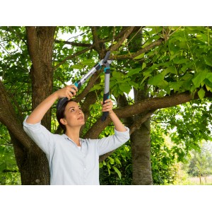 Frau schneidet Äste mit Gardena EasyCut 500 B Astschere im Garten.