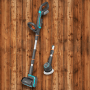 Gardena Akku-Multi-Reiniger AquaBrush Universal mit Walzen- und Tellerbürste vor Holzwand.