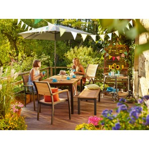 Gartenszene mit Holz Stapelstuhl Bonlee FSC®, Tisch und Deko auf Terrasse.