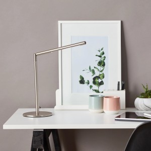 Moderne LED-Tischleuchte Bombay Eisen auf Schreibtisch mit Deko. Schwenkbarer Kopf für optimale Beleuchtung.
