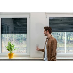 Mann bedient Schellenberg Rollladenschalter Unterputz in Weiß. Rollladensteuerung im Innenraum.