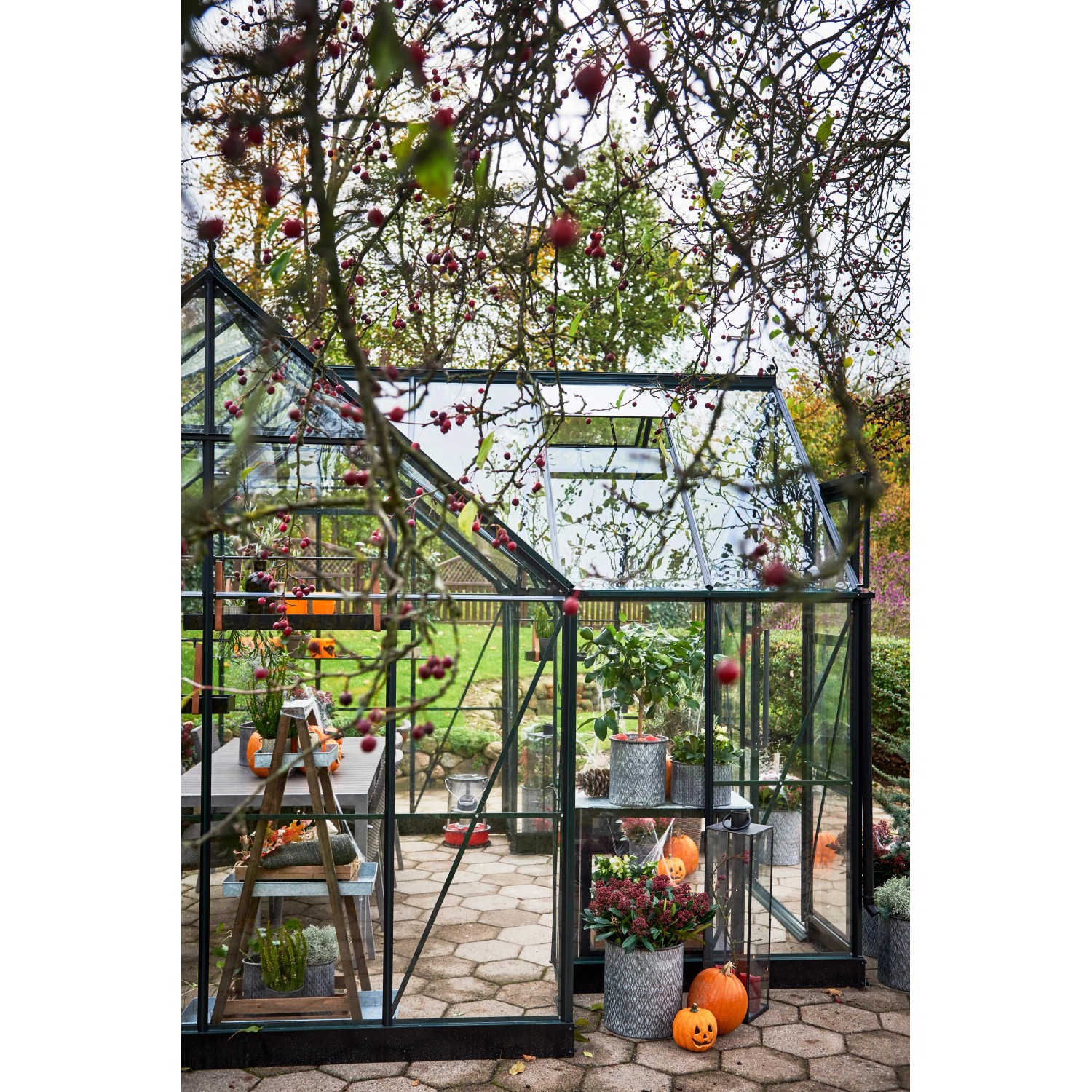 Halls Gewächshaus Garden Room, 12,9 m², grüne Aluminiumstruktur mit Glas, bepflanzt und dekoriert.