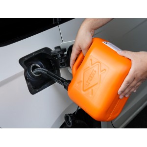 Orangefarbener OBI Benzinkanister (5 l) beim Befüllen eines Autotanks.