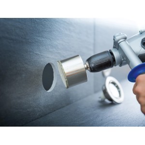 LUX Lochsäge Professional Ø 60 mm im Einsatz: Bohren eines Lochs in eine graue Fliese mit Diamant-Sägerand.