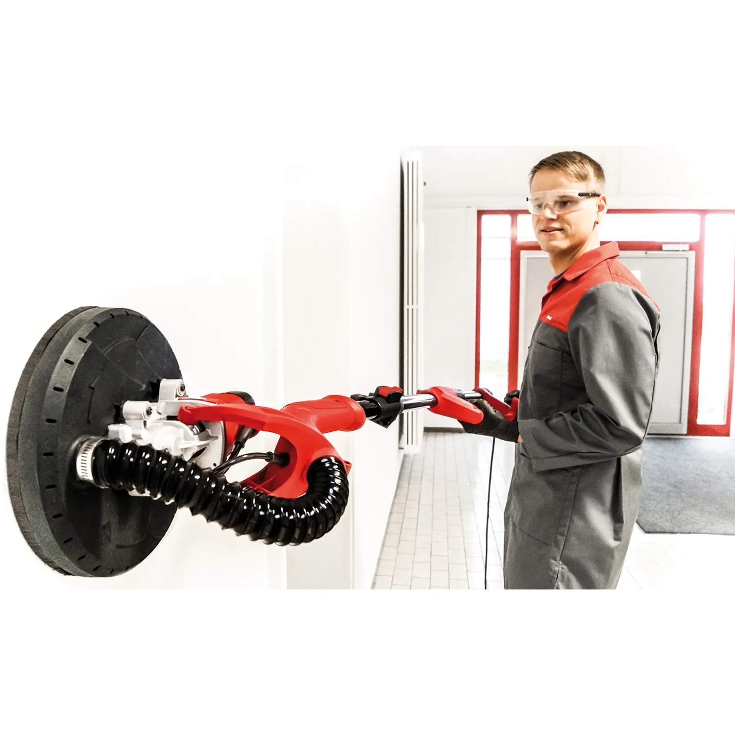 Einhell Trockenbauschleifer TC-DW 225 mit Mann beim Schleifen einer Wand.