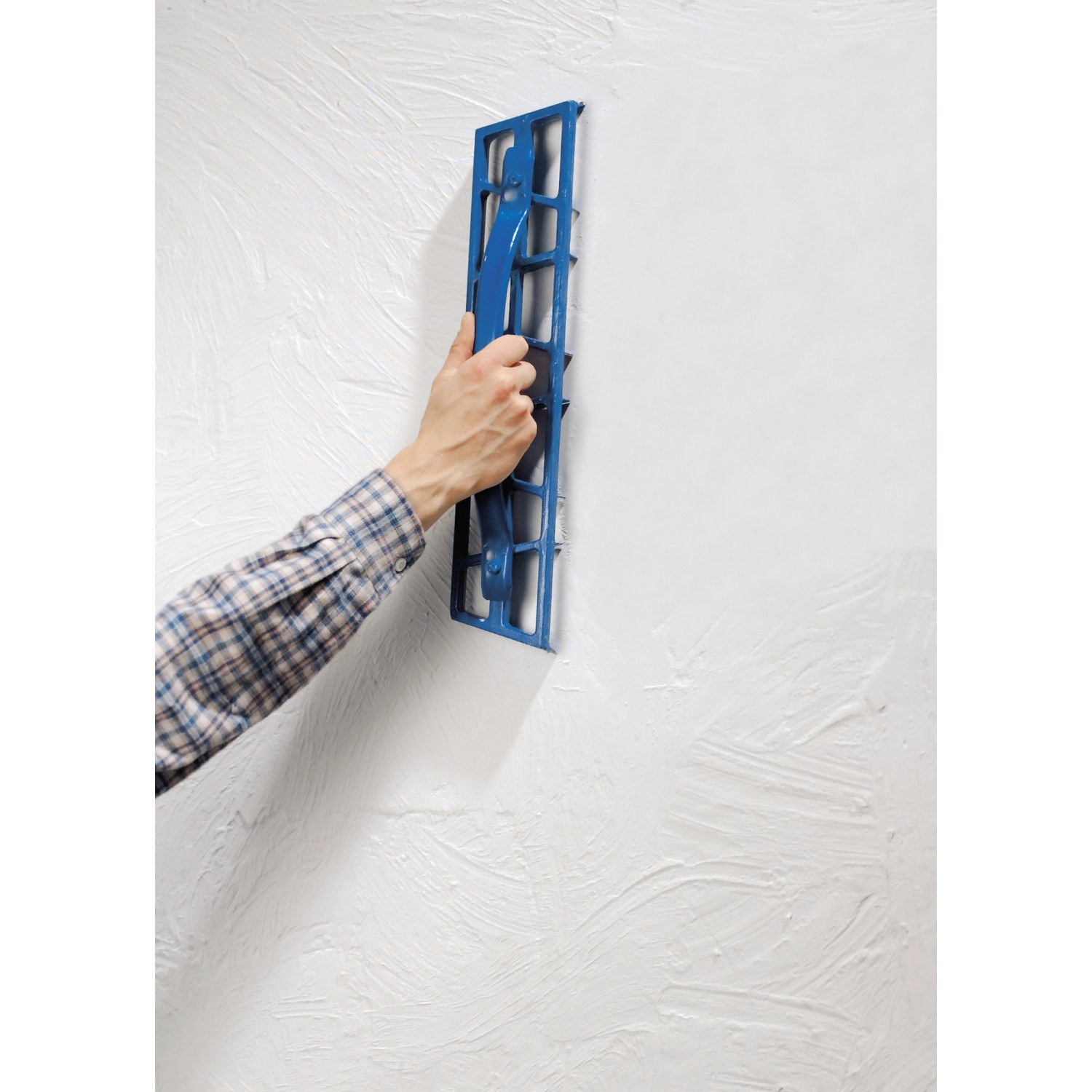 LUX Gipserhobel 50 cm im Einsatz: Hand hobelt Gips an einer weißen Wand. Ideal für Trockenbauarbeiten.