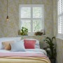 Schlafzimmer mit Laura Ashley Vliestapete Forsythia Sunshine mit gelbem Blütenmuster.
