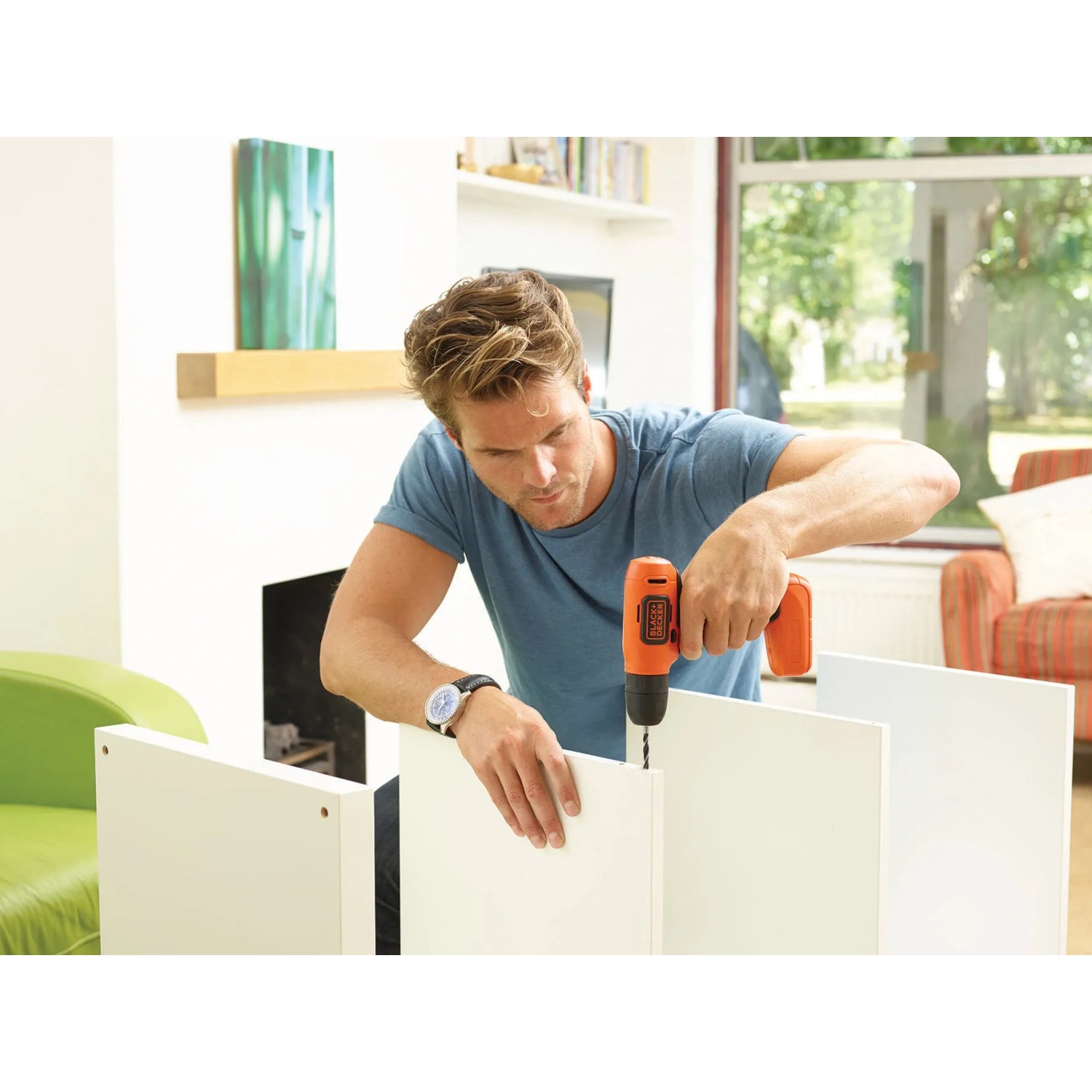 Mann bohrt mit Black+Decker Akku-Bohrschrauber BDCD8 in ein weißes Möbelstück.