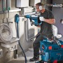 Anwendung der Bosch Professional GDE 68 Staubabsaugung mit Bohrhammer an einer Wand.