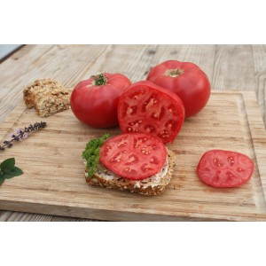 Rosafarbene Blu Tomate Rose Crush auf Holzbrett, ganze und geschnittene Frucht.