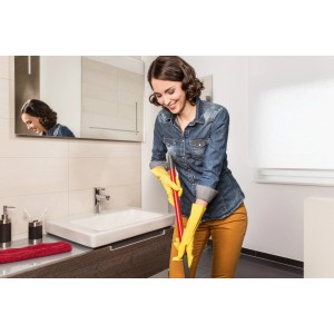 Frau wischt Bad mit Vileda Der Griffige Universal Grip M Haushaltshandschuhen in Gelb.