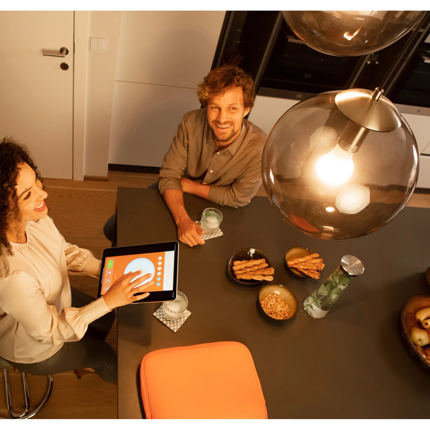 Szene mit Ledvance Sun@Home Smart+ Glühbirne in Glühlampenform, gesteuert per Tablet, für Wohlfühllicht.