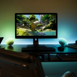 Philips Hue Go Tischlampe auf Schreibtisch mit PC, farbig beleuchtet.