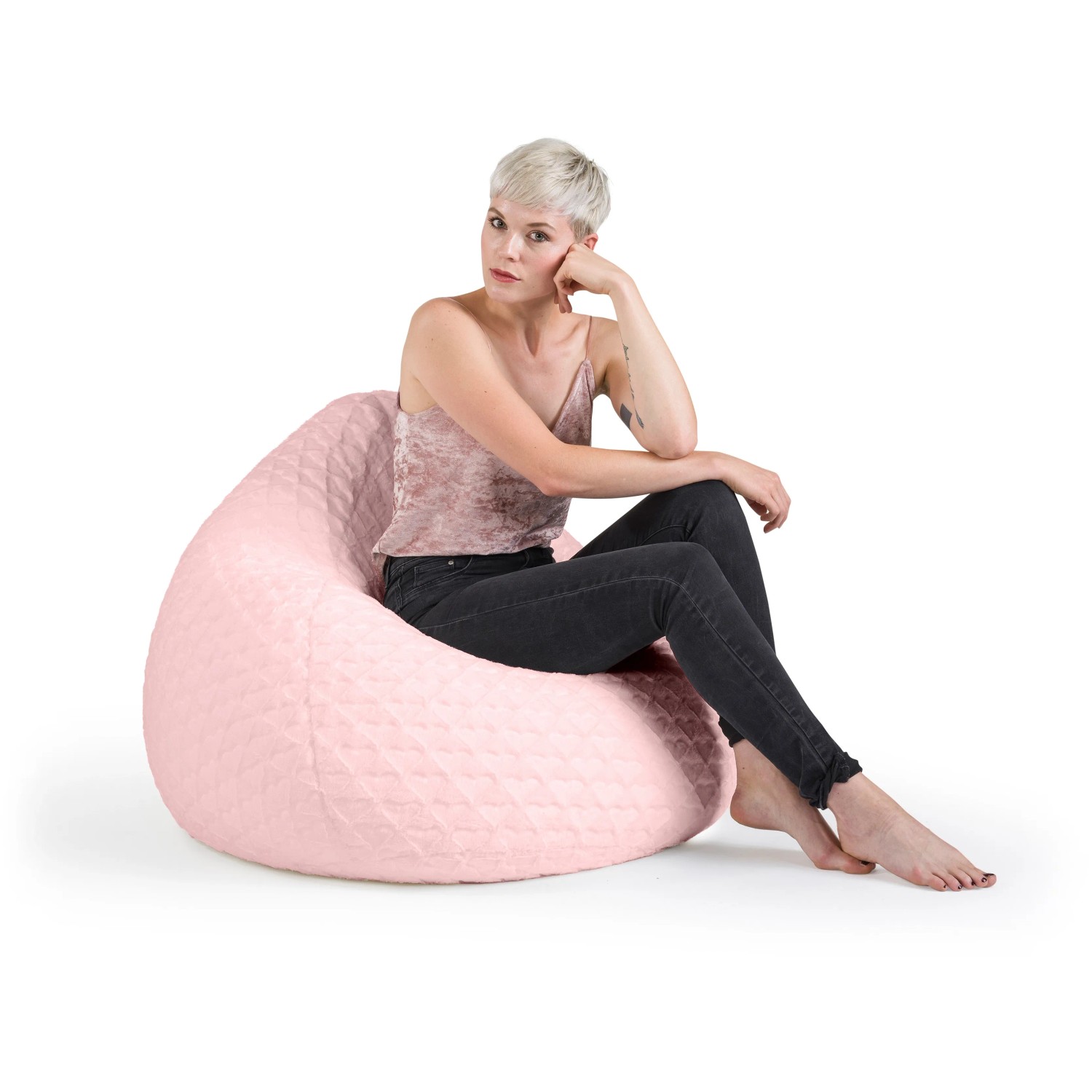 Rosa Sitzsack BeanBag mit Herzmuster, 220 l, Frau sitzt entspannt darauf.