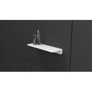 Weiße, selbstklebende Schütte Duschablage mit Duschutensilien an dunkler Wand.