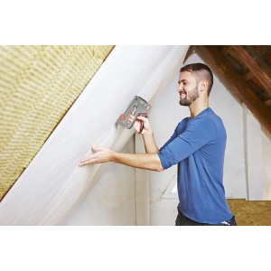 Mann tackert Folie mit Novus Profi Handtacker J-29 im Dachgeschoss.