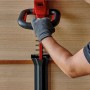 Einhell Akku-Heckenschere Arcurra 18/55 in Benutzung, rote Gehäuse, schwarzer Griff und graue Handschuhe.