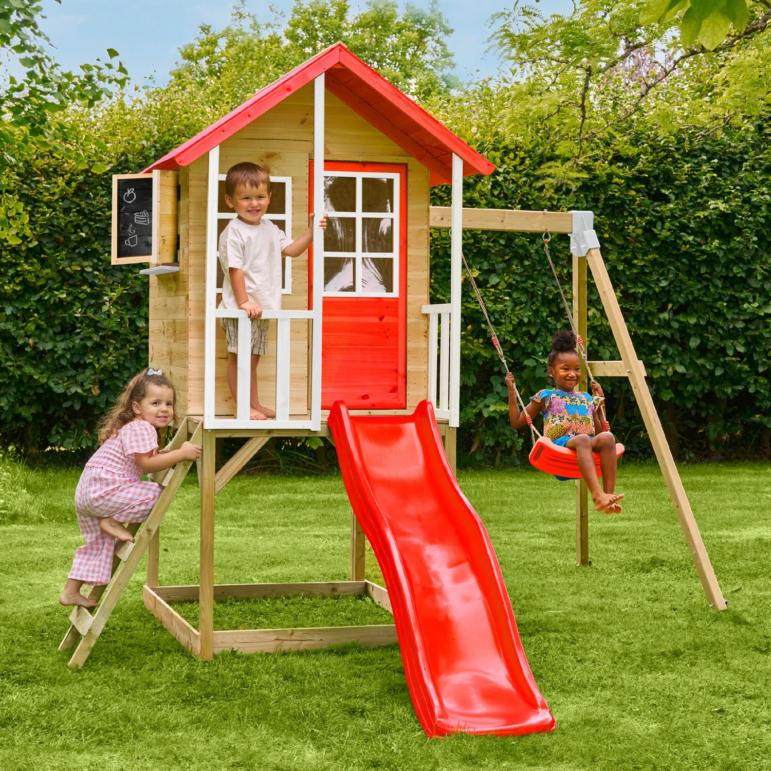 Zwerkules Spielhaus Lolla mit Rutsche, Schaukel und spielenden Kindern im Garten.